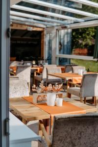 an outdoor patio with tables and chairs and windows at Bed & Breakfast Landhaus Strasser in Söll