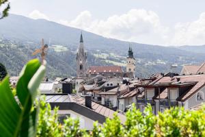 Blick auf eine Stadt mit Bergen im Hintergrund in der Unterkunft Soley Suites - adults only in Brixen