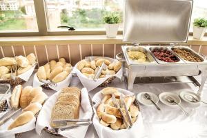 un buffet con diversi tipi di pane e altri prodotti alimentari di Boreas Apart Hotel a Fortaleza