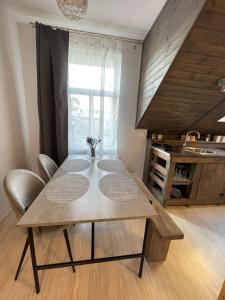 a dining room table and chairs in a kitchen at Apartamenti Starp Krastiem 2 in Liepāja