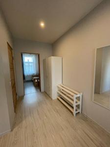 an empty room with a white refrigerator in a room at Apartamenti Starp Krastiem 2 in Liepāja