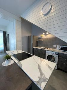 a kitchen with a counter and a clock on the wall at Apartamenti Starp Krastiem 2 in Liepāja