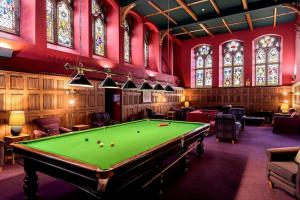 een kamer met een pooltafel en glas-in-loodramen bij LOCH NESS - Luxury Highland Retreat in Scotland in Fort Augustus