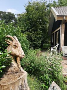 une statue de chèvre devant une maison dans l'établissement Logeren bij De Soerensesteeg, à Uddel