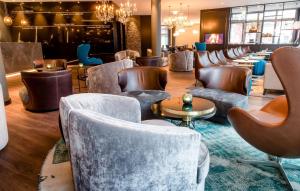 a lobby with a row of chairs and tables at Motel One Berlin-Bellevue in Berlin