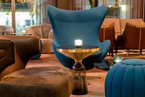 a room with a blue chair and a table and a stool at Motel One Berlin-Bellevue in Berlin