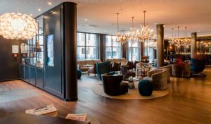 a lobby of a hotel with chandeliers and a bar at Motel One Berlin-Bellevue in Berlin