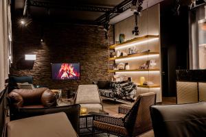 a living room with leather furniture and a brick wall at Motel One Stuttgart-Mitte in Stuttgart