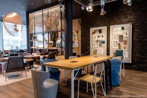 a restaurant with tables and chairs and a brick wall at Motel One Stuttgart-Mitte in Stuttgart