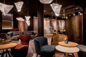 a lobby with tables and chairs and a couch at Motel One Stuttgart-Mitte in Stuttgart