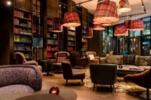 biblioteca con sofás, sillas y estanterías en Motel One Manchester-St. Peter´s Square, en Mánchester