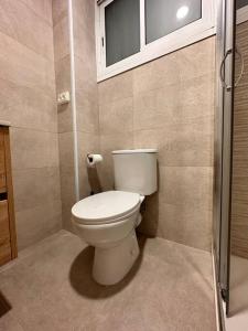 a bathroom with a toilet and a window at A pie de PLAYA in La Pineda