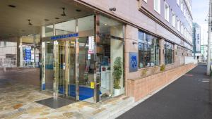 una tienda con puertas giratorias en una calle en Toyoko Inn Chofu Keio sen Fuda eki, en Chofu