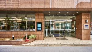 una tienda frente a un edificio con una puerta giratoria en Toyoko Inn Osaka Tenjinbashi-suji Rokuchome, en Osaka