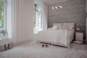 um quarto com uma cama branca e uma parede estampada em Boutique Suites Heidelberg Alte Zigarrenmanufaktur em Heidelberg