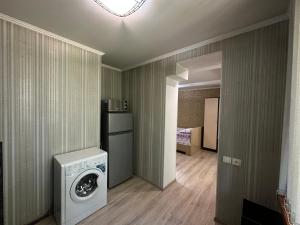 (( Turksib ))One-room apartment opposite Almaty Airport的洗衣房配有洗衣机和烘干机