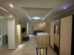 (( Turksib ))One-room apartment opposite Almaty Airport的一间卧室配有一张床和一个沙发