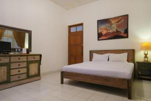 ein Schlafzimmer mit einem Bett und einer Kommode in der Unterkunft RedDoorz at Griya Cemara Homestay Yogyakarta in Yogyakarta