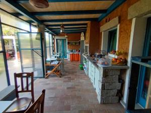 a kitchen with a stone counter top and a table at PortoPollo SurfHouse in Barrabisa