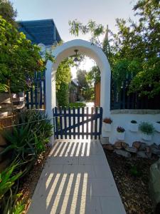 an archway leading into a yard with a fence at PortoPollo SurfHouse in Barrabisa