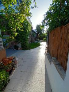 an empty sidewalk in a yard with a fence at PortoPollo SurfHouse in Barrabisa