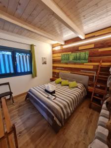 a bedroom with a bed and a wooden wall at PortoPollo SurfHouse in Barrabisa