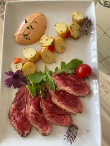 a plate of food with meat and vegetables on it at Salon Boyer in Épernay