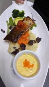 a plate of food with fish and vegetables and a sauce at Salon Boyer in Épernay