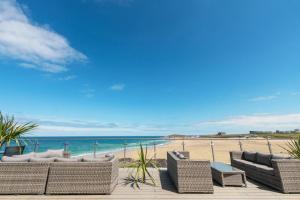 un gruppo di sedie su una spiaggia con l'oceano di Fistral Beach Hotel and Spa - Adults Only a Newquay