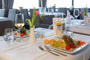 een tafel met twee borden eten en glazen wijn bij Haus Rebland Urlaubsglück-Hotel in Baden-Baden