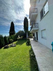 een tuin van een huis met een grasveld bij Vista Apartments in Trebinje