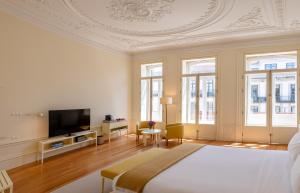 een witte kamer met een bed en een televisie bij Casa do Arquiteto Boutique Townhouse - Adults Only in Porto