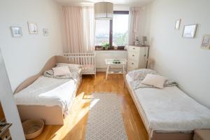 Cette petite chambre comprend 2 lits et une fenêtre. dans l'établissement Apartmán NINA, à Veľká Lomnica