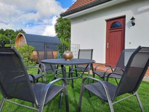 - une table et des chaises dans une cour avec une porte rouge dans l'établissement Ein Stück Glück, à Prerow