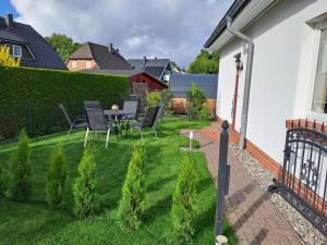 une petite arrière-cour avec une table et des chaises sur l'herbe dans l'établissement Ein Stück Glück, à Prerow