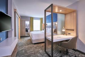 SpringHill Suites by Marriott Detroit Dearborn في ديربورن: غرفة في الفندق مع سرير ومكتب