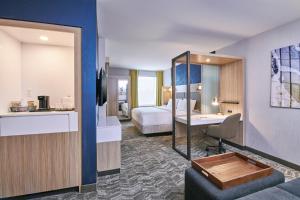 SpringHill Suites by Marriott Detroit Dearborn في ديربورن: غرفة في الفندق بسرير ومكتب في الغرفة