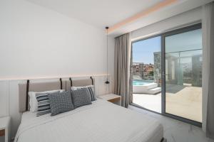 a bedroom with a bed and a balcony with a tub at Arcs Suites & Residences in Mýkonos City