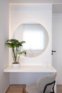 a mirror on a shelf with a chair and a plant at Luxury 4 Bedrooms Apartment Near Flisvos Marina in Piraeus