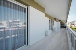 a balcony with large windows and a view of the city at Luxury 4 Bedrooms Apartment Near Flisvos Marina in Piraeus