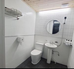 Baño blanco con aseo y lavamanos en Jeju Soroan Pension, en Seogwipo