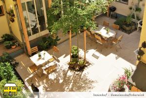 una vista aérea de un patio con un árbol y sillas en Das Gelbe Haus - Drei besondere Ferienwohnungen, en Flensburg