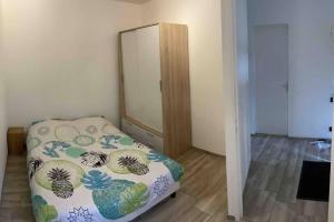 Dormitorio pequeño con cama y espejo en Logement 3 personnes., en Vitry-le-François