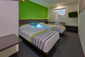 מיטה או מיטות בחדר ב-City Express Junior by Marriott Puebla FINSA