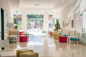 een lobby met kleurrijke stoelen en tafels in een gebouw bij 3HB Clube Humbria - All Inclusive in Albufeira