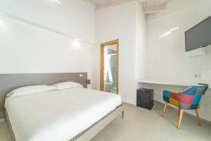 Schlafzimmer mit einem Bett, einem Schreibtisch und einem TV in der Unterkunft Nuova -Luxury Rooms & Apartment- in Olbia