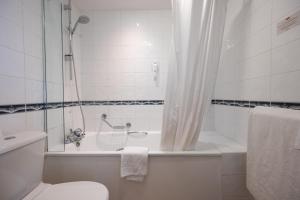 y baño con bañera, aseo y ducha. en Antelope by Greene King Inns, en Poole