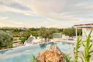 una piscina con una roccia in primo piano di Trulli Terra Magica a Putignano