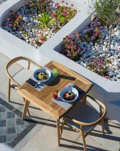 a table with two plates of food on it on a patio at Danae Suites Santorini in Oia