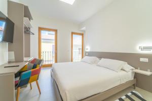 Schlafzimmer mit einem Bett, einem Schreibtisch und einem Stuhl in der Unterkunft Nuova -Luxury Rooms & Apartment- in Olbia